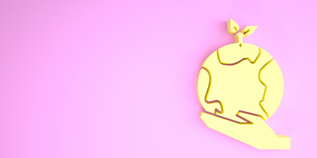 Hand holding a globe on a pink background
