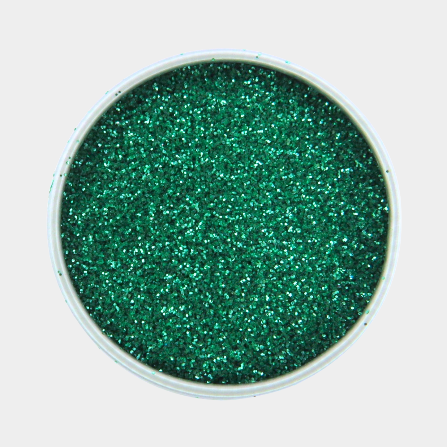 Green glitter in a small round container on a light gray background