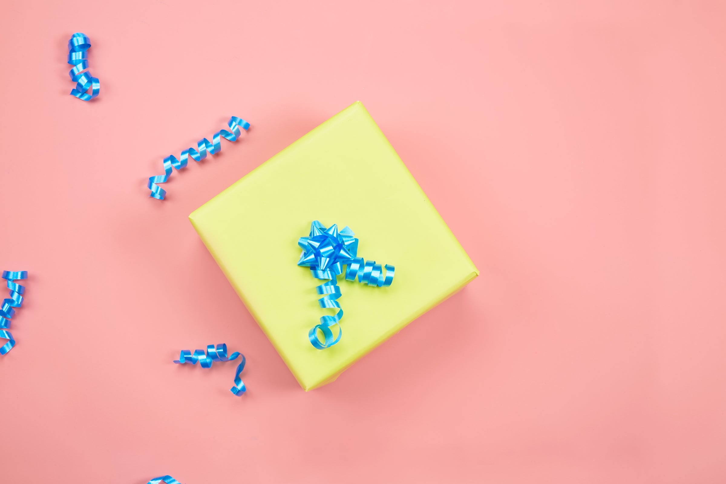 Pink background with a yellow gift and blue gift ribbon
