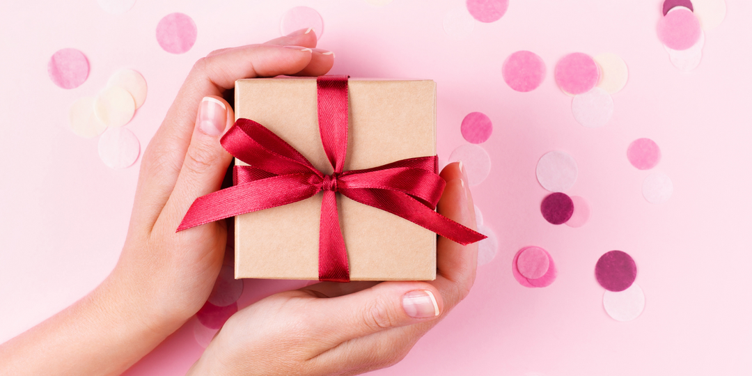 Gift with a red bow on a pink background