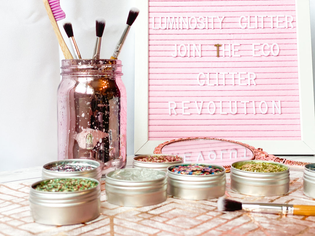 DIY eco glitter bar setup with makeup brushes and large tins of eco glitter for weddings