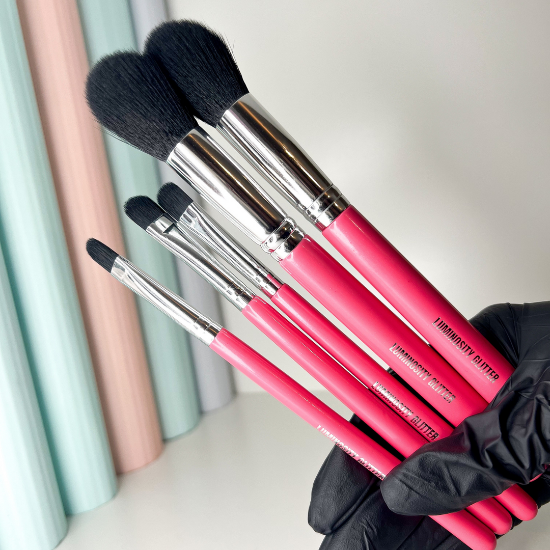 Hot pink wooden makeup brushes with aluminium ferrule and black synthetic hairs.