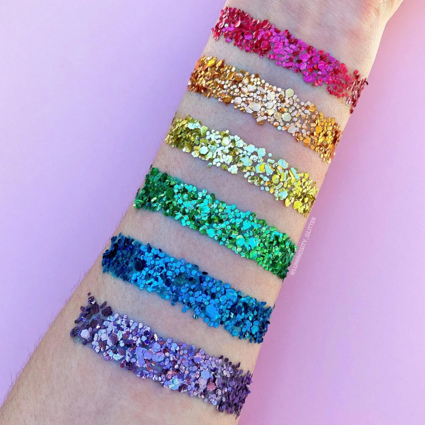 Arm swatch of rainbow biodegradable glitter. Red, orange, gold, green, blue and purple bio glitter.