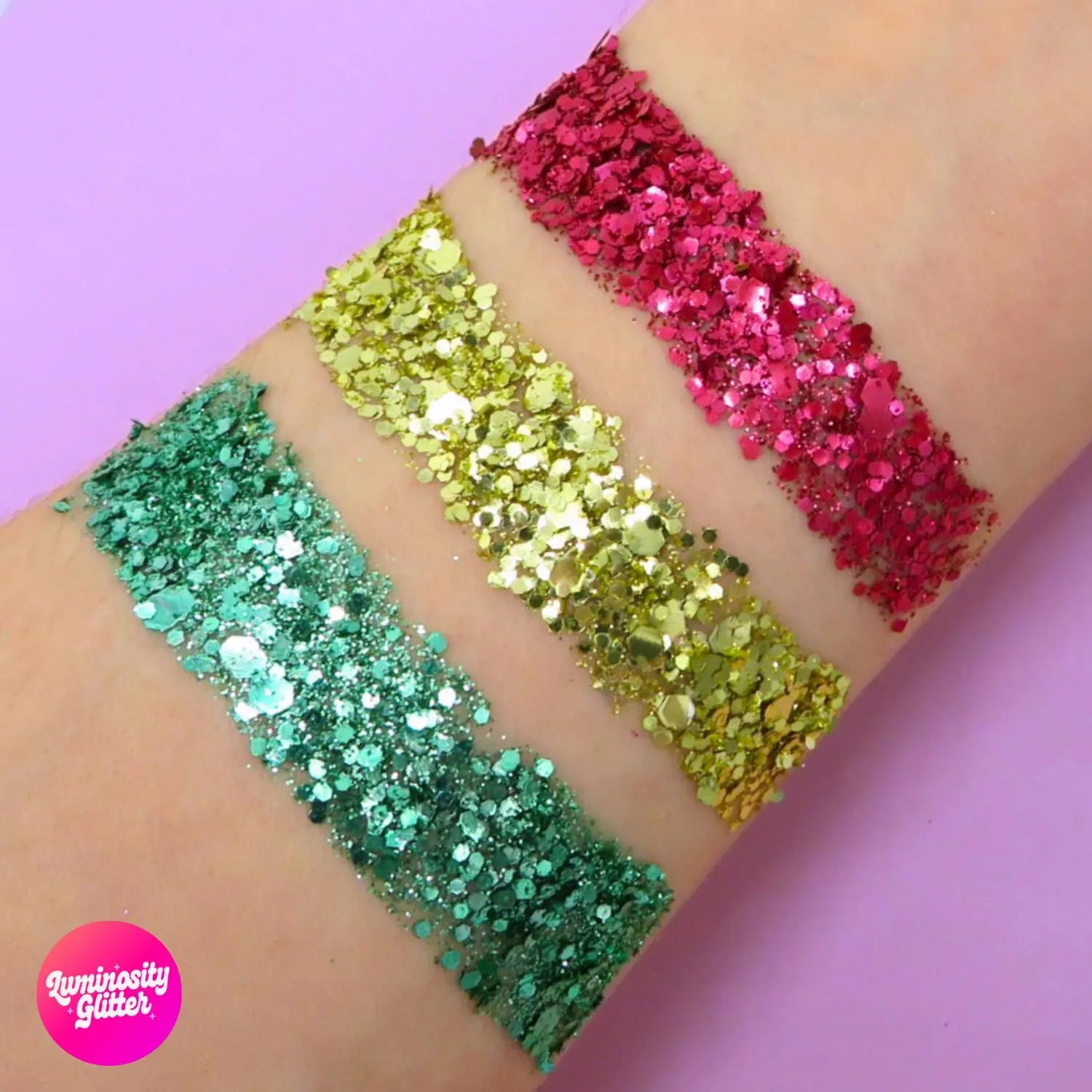 Christmas eco glitter swatch of red, gold and green eco glitter blends on an arm.