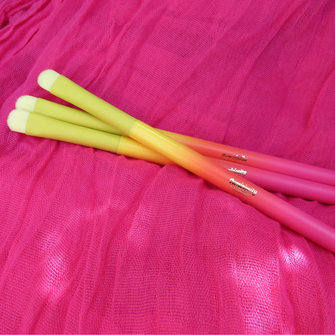 Concealer brush in ombre pink, orange and yellow for applying cosmetic glitter