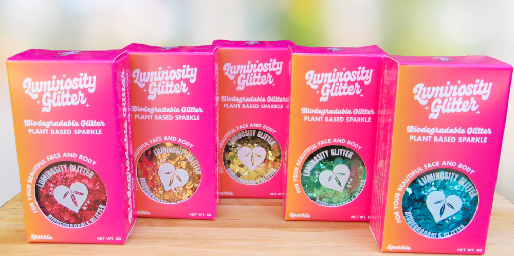 Biodegradable glitter by Luminosity Glitter in pink and orange ombre packaging