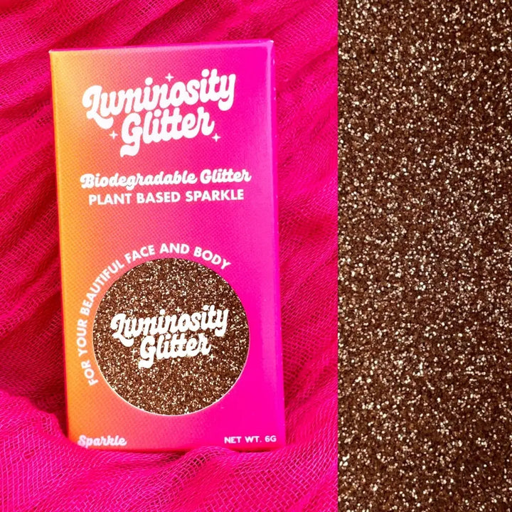 Fine rose gold biodegradable cosmetic grade glitter for glitter eyeshadow, makeup, christmas makeup and crafting. In a bright pink and orange ombre packaging box.