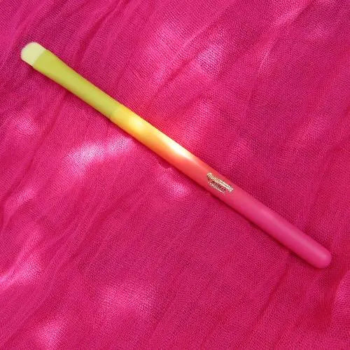 glitter application brush with yellow synthetic bristles and aluminium ferrule and wooden handle in bright ombre yellow and pink.