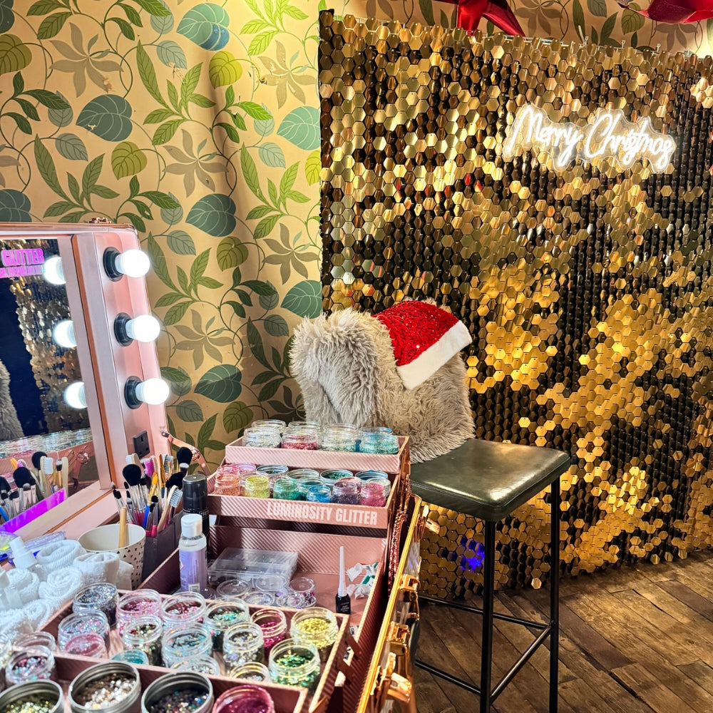 Gold luxury sequin wall hire alongside eco glitter bar hire for christmas parties with our merry christmas neon sign.