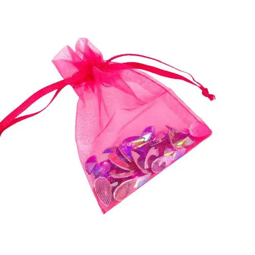 A pink organza drawstring bag filled with purple reusable face and body gems