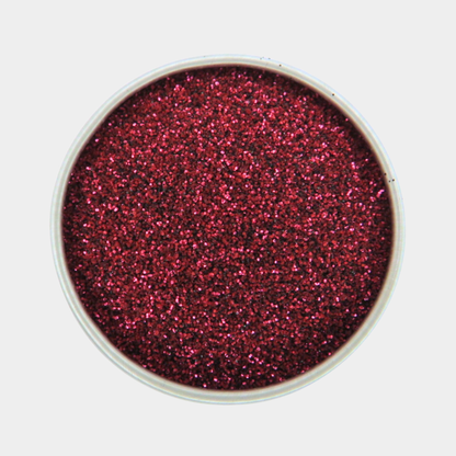 Red glitter in a small container on a white background
