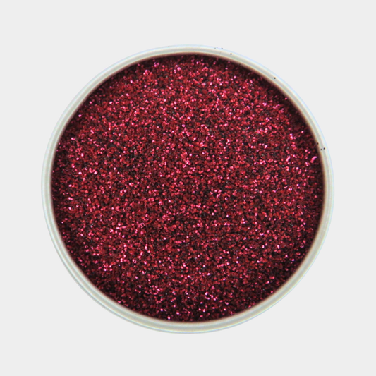 Red glitter in a small container on a white background