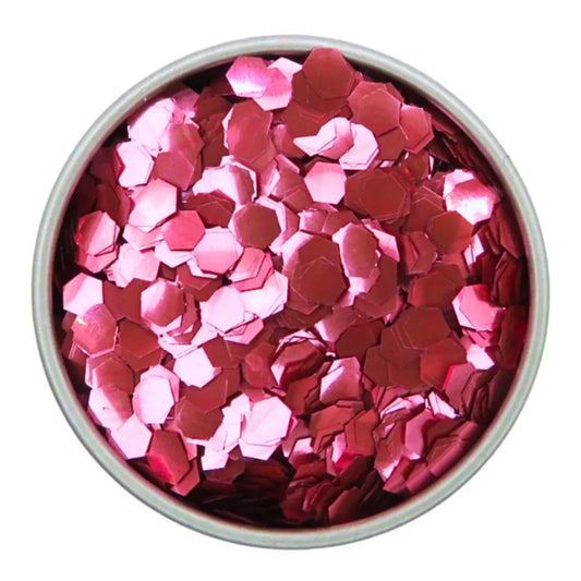 Rose pink super chunky biodegradable cosmetic glitter suitable for use on your face, body hair and nails. A close up image of the glitter in a round aluminium tin.