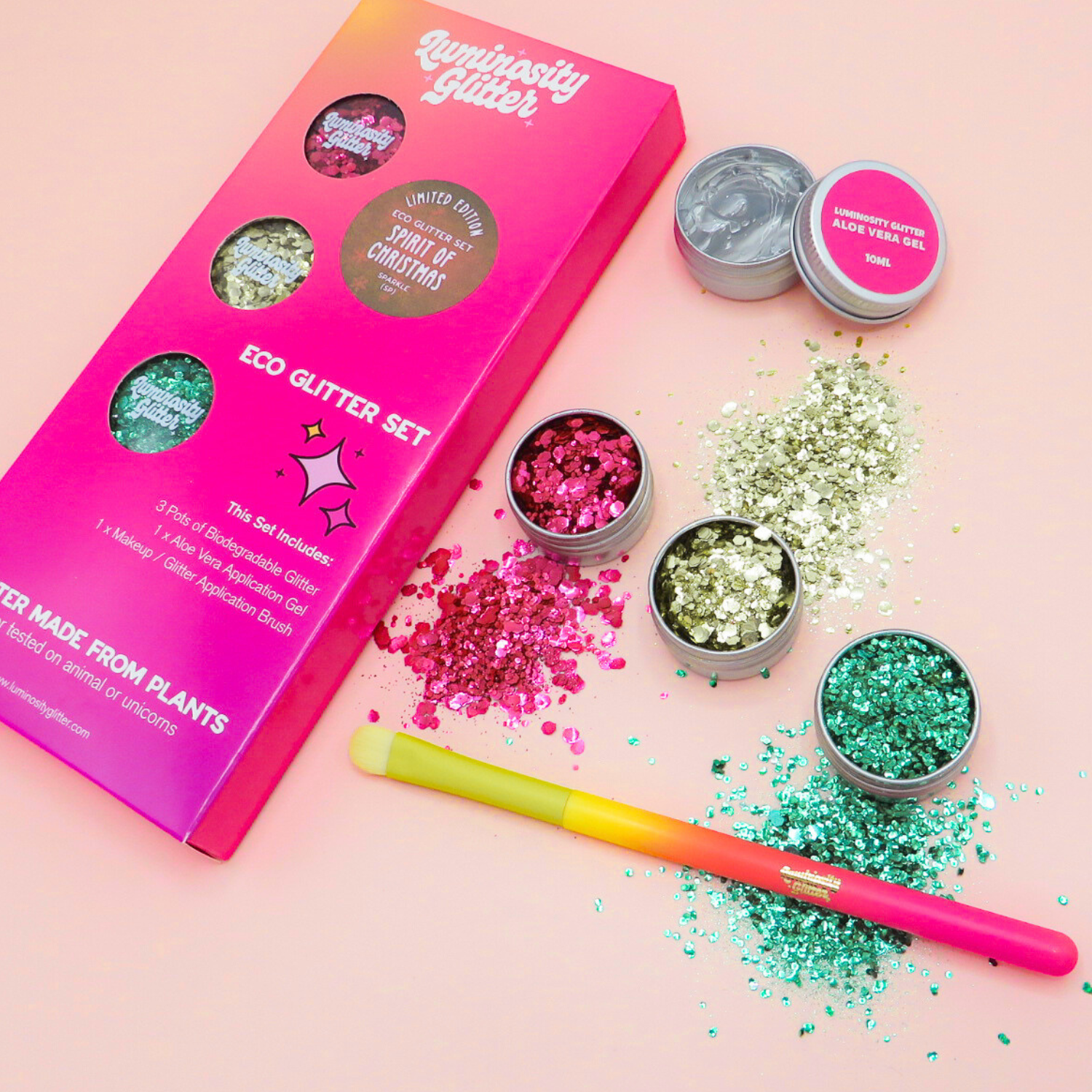 Glitter set with pink packaging and various glitter containers on a pink background