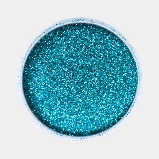 Turquoise glitter in a small round container on a light gray background
