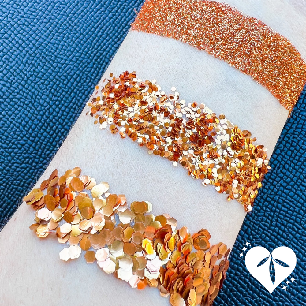 Swatch on arm of fine, chunky and ultra chunky orange eco glitter
