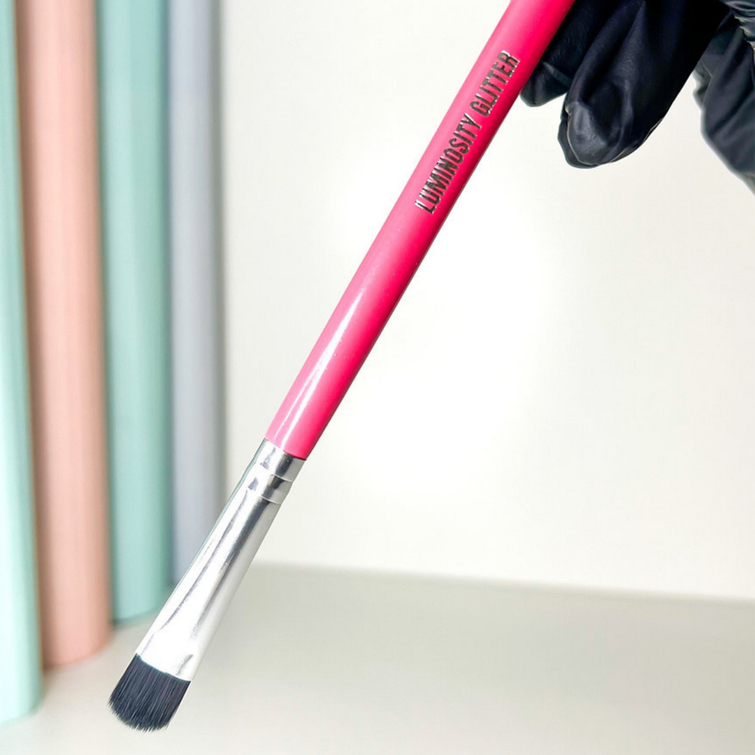 Luminosity Glitter Small Hot Pink Makeup Brush with a wooden handle and black synthetic hairs