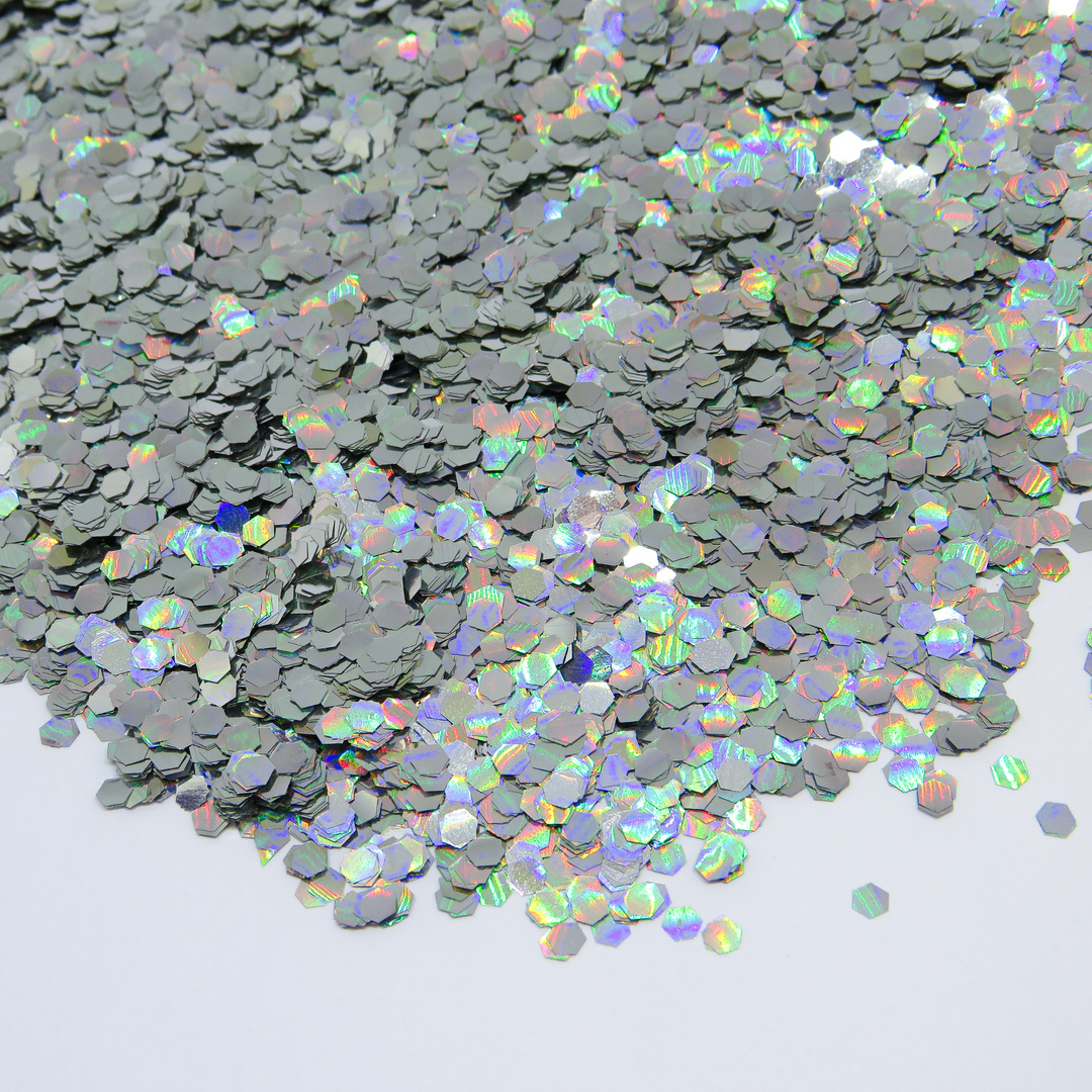 Holographic silver bioglitter in ultra chunky hexagon shape is a cosmetic glitter suitable for vegetarians.