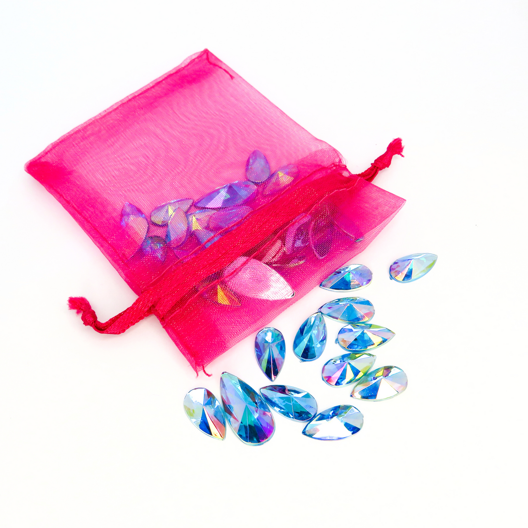 Ice blue reusable face gems in a mini pink organza draw string bag by Luminosity glitter. Perfect for festivals and makeup.