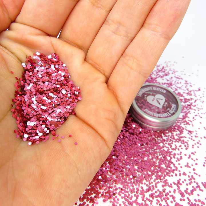 A scoop of rose pink biodegradable glitter in chunky size.
