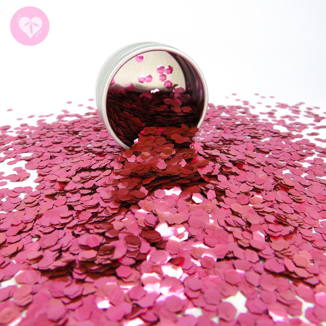 Rose pink ultra chunky biodegradable glitter spilling out of an aluminium tin by Luminosity Glitter.